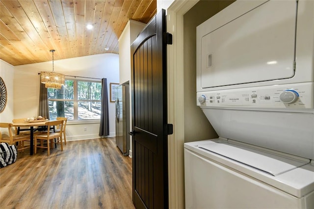 clothes washing area with stacked washer and dryer, hardwood / wood-style floors, and wooden ceiling