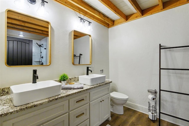 bathroom featuring vanity, wood-type flooring, toilet, and beamed ceiling