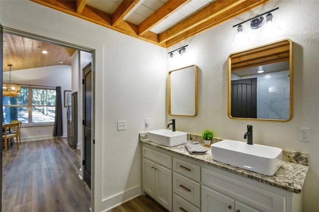 bathroom featuring a notable chandelier, wood-type flooring, vanity, and vaulted ceiling with beams