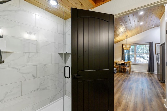 bathroom with hardwood / wood-style flooring, vaulted ceiling, wooden ceiling, and a shower with door