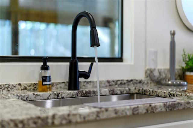 interior details featuring stone countertops and sink