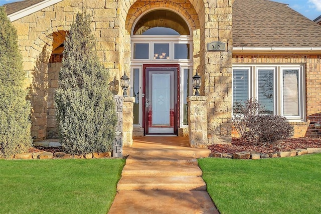 entrance to property featuring a lawn