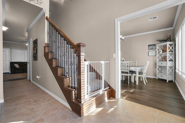 stairway with tile patterned flooring and crown molding