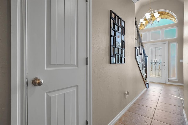 entrance foyer with light tile patterned flooring and a notable chandelier