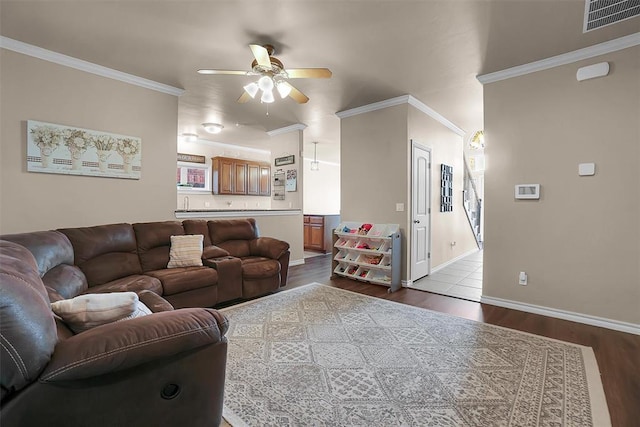 living room with crown molding, ceiling fan, and light hardwood / wood-style floors