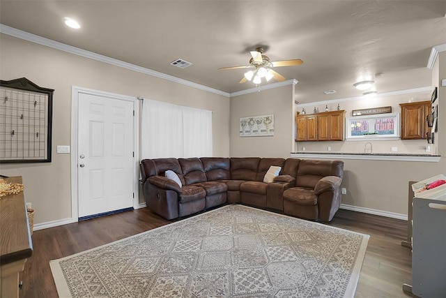 living room featuring crown molding, dark wood-type flooring, sink, and ceiling fan