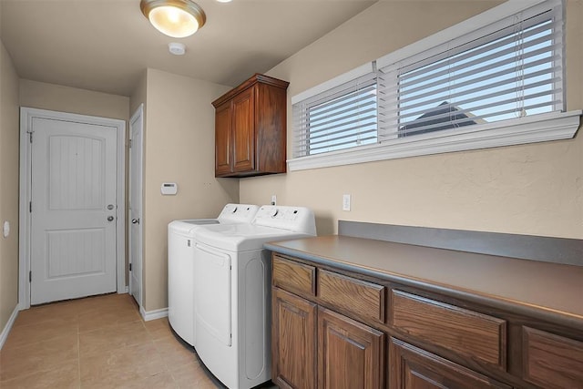 washroom with separate washer and dryer, light tile patterned floors, and cabinets