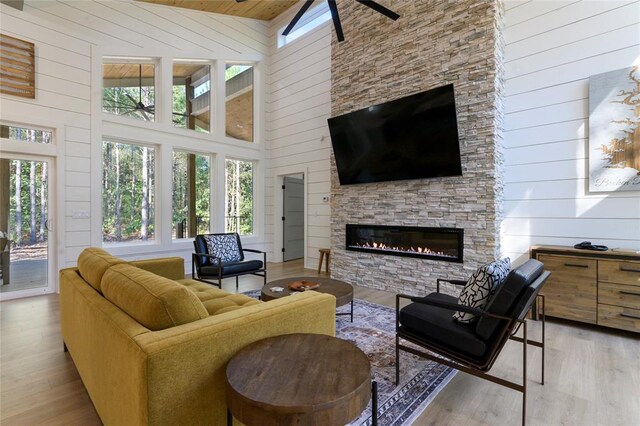 living room featuring a wealth of natural light, high vaulted ceiling, and light hardwood / wood-style flooring