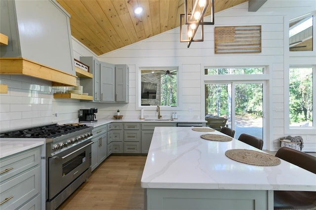 kitchen featuring lofted ceiling, a center island, stainless steel range, and wood ceiling