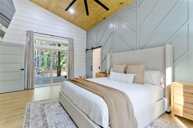 bedroom featuring access to outside, ceiling fan, light hardwood / wood-style floors, a barn door, and wooden ceiling