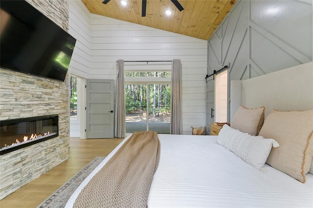 bedroom featuring high vaulted ceiling, access to exterior, wood ceiling, a barn door, and light wood-type flooring