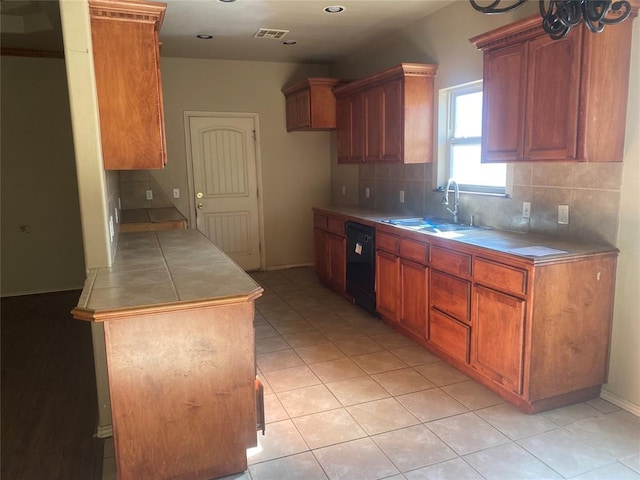 kitchen with light tile patterned flooring, dishwasher, sink, and decorative backsplash