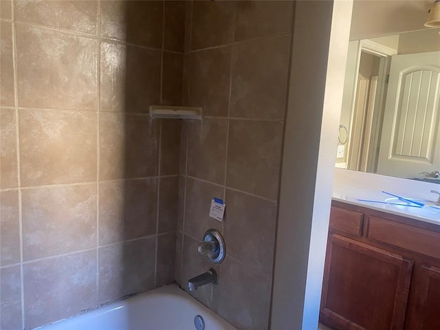 bathroom featuring vanity and tiled shower / bath