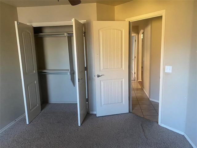 unfurnished bedroom featuring a closet and dark colored carpet