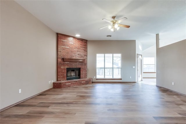 unfurnished living room featuring ceiling fan, a fireplace, and light hardwood / wood-style floors