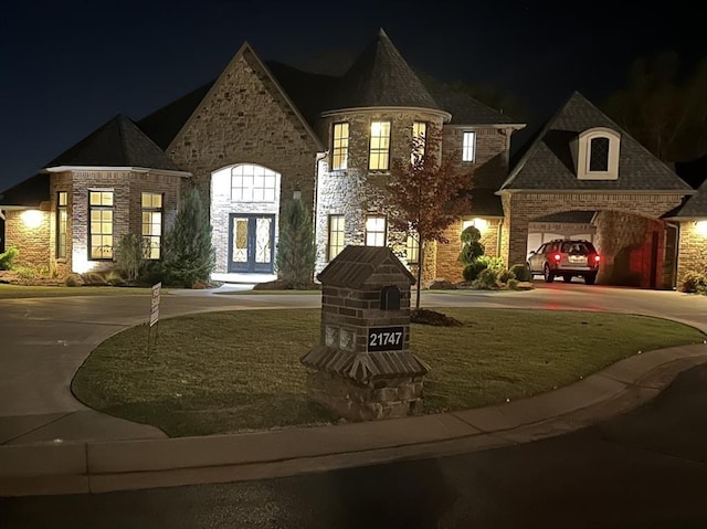 view of front of property with a garage and a yard