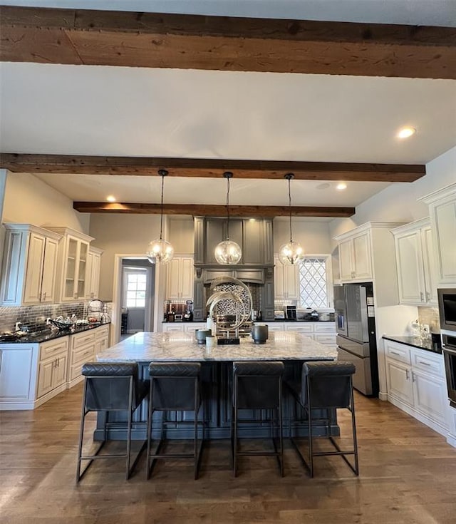 kitchen with dark stone counters, hanging light fixtures, and backsplash