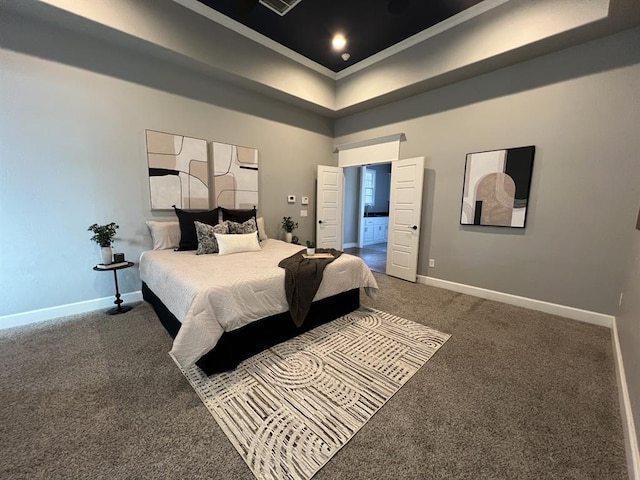 bedroom with a tray ceiling, a towering ceiling, ensuite bath, and carpet flooring