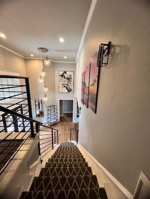 stairs with hardwood / wood-style floors and crown molding