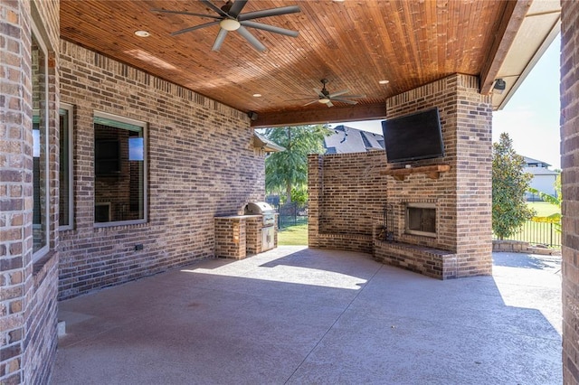 view of patio / terrace featuring an outdoor brick fireplace, ceiling fan, and exterior kitchen