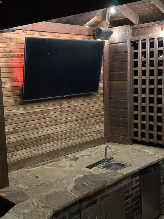 interior details featuring dishwasher, sink, and wood walls