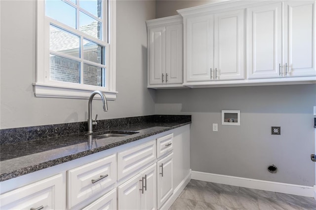 clothes washing area with hookup for a washing machine, electric dryer hookup, sink, and cabinets