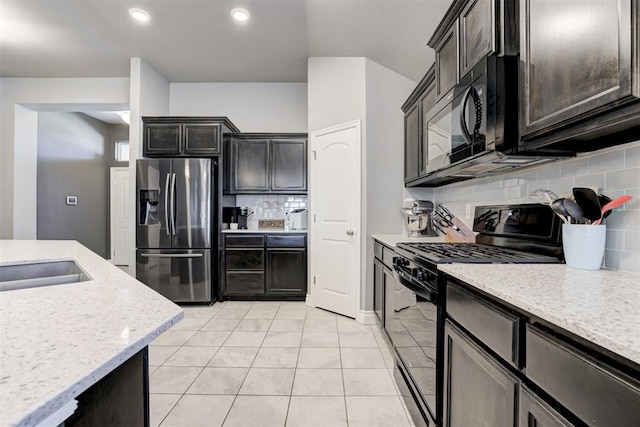 kitchen with black appliances, dark brown cabinets, light tile patterned floors, light stone countertops, and backsplash