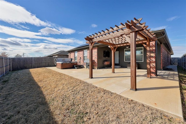 back of property with a hot tub, a patio, and a pergola