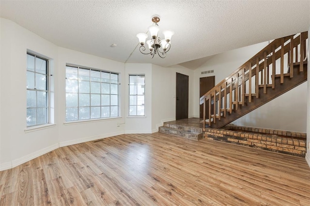 9718 Hummingbird Ln, Oklahoma City, OK 73162 - interior space featuring lofted ceiling, wood-type flooring, a chandelier, and a textured ceiling