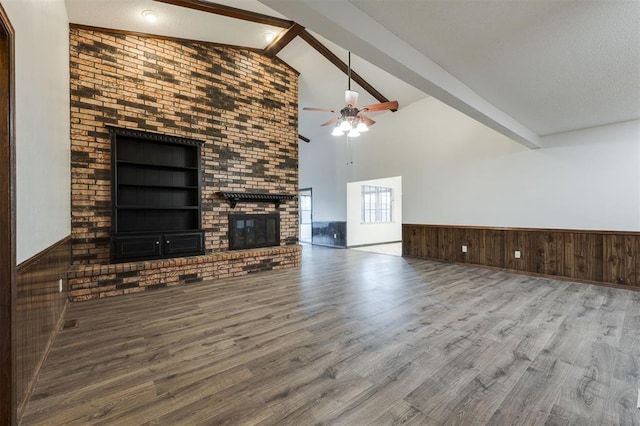 9718 Hummingbird Ln, Oklahoma City, OK 73162 - unfurnished living room with a fireplace, wooden walls, beamed ceiling, wood-type flooring, and a textured ceiling
