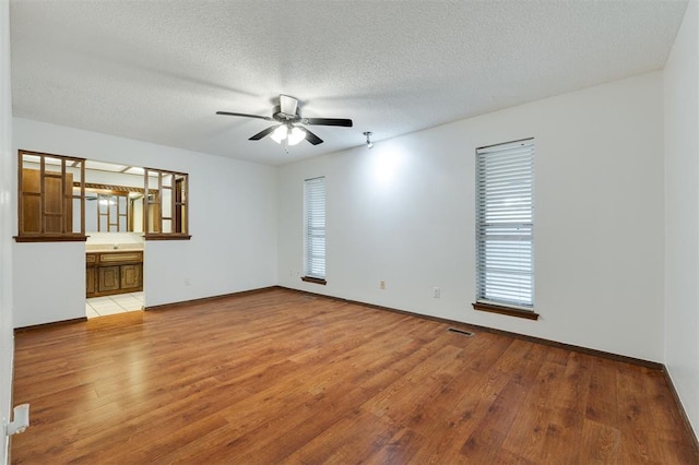 9718 Hummingbird Ln, Oklahoma City, OK 73162 - spare room featuring ceiling fan, light wood-type flooring, and a textured ceiling