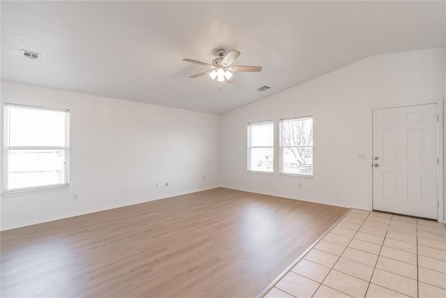 tiled empty room featuring lofted ceiling and ceiling fan