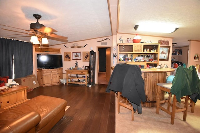 living room featuring lofted ceiling with beams, hardwood / wood-style flooring, ornamental molding, bar, and ceiling fan