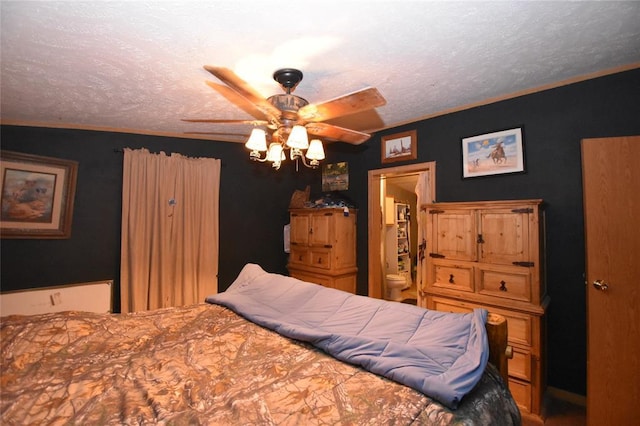 bedroom with ceiling fan, connected bathroom, and a textured ceiling