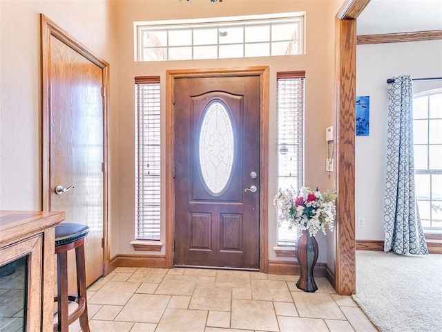 carpeted foyer featuring ornamental molding