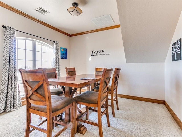 dining space featuring crown molding and light colored carpet