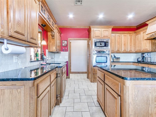 kitchen featuring sink, a kitchen island, ornamental molding, and appliances with stainless steel finishes