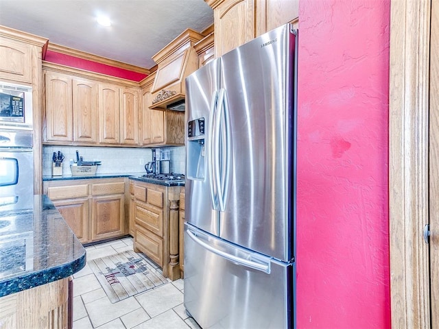 kitchen featuring dark stone counters, decorative backsplash, light tile patterned floors, stainless steel appliances, and crown molding