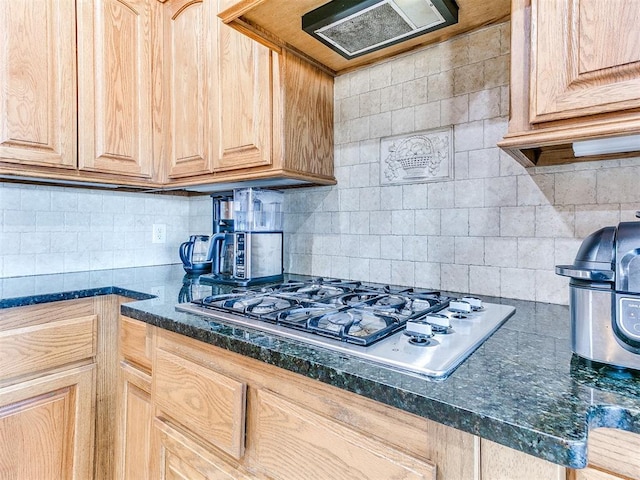 kitchen with light brown cabinetry, ventilation hood, stainless steel gas cooktop, and backsplash