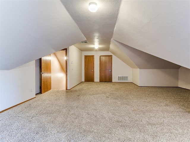 additional living space featuring carpet floors and vaulted ceiling