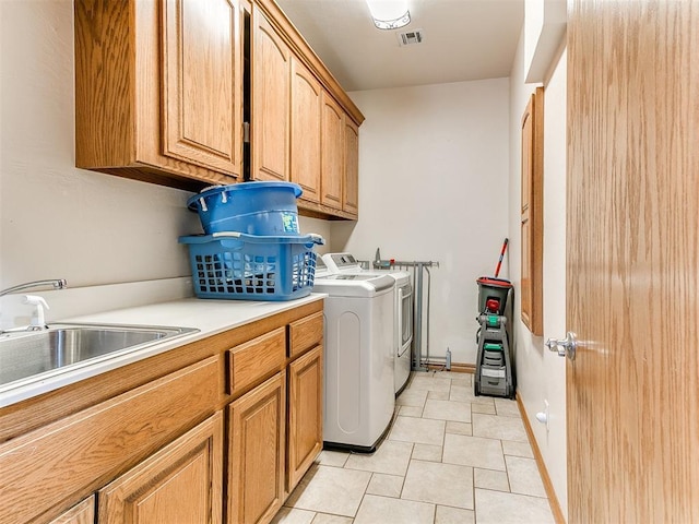 washroom with independent washer and dryer, sink, cabinets, and light tile patterned floors