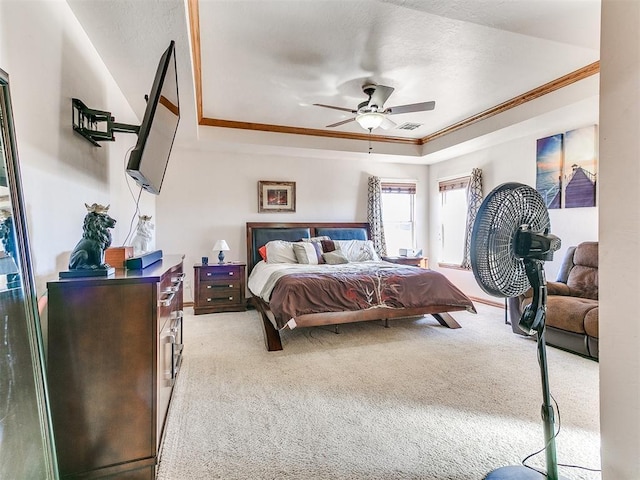 bedroom with crown molding, light carpet, ceiling fan, and a tray ceiling