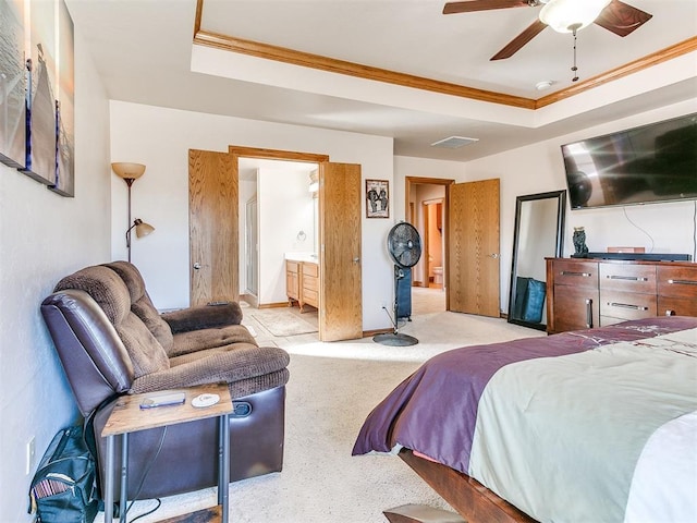 carpeted bedroom with ceiling fan, ornamental molding, connected bathroom, and a tray ceiling