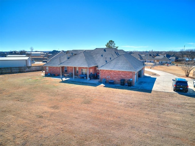 back of property with a yard and a patio