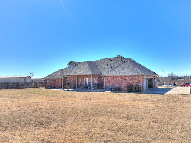 rear view of house with a garage and a lawn