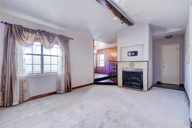 unfurnished living room with a brick fireplace, vaulted ceiling with beams, and light colored carpet