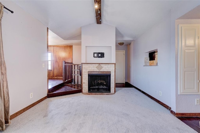 unfurnished living room featuring a fireplace, carpet floors, and vaulted ceiling with beams