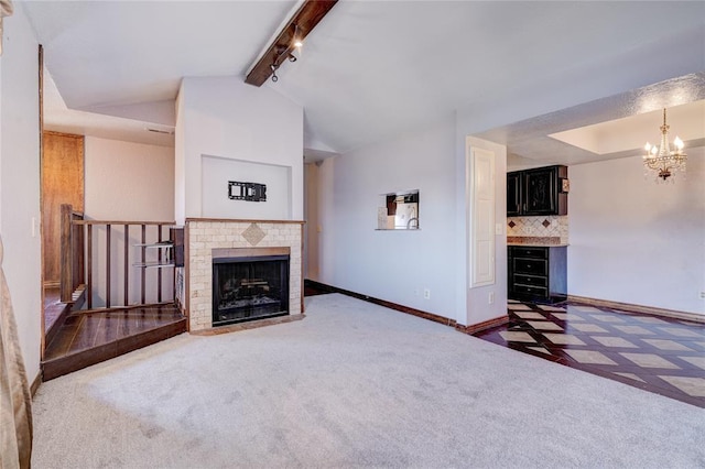 unfurnished living room with an inviting chandelier, a fireplace, carpet, and vaulted ceiling with beams