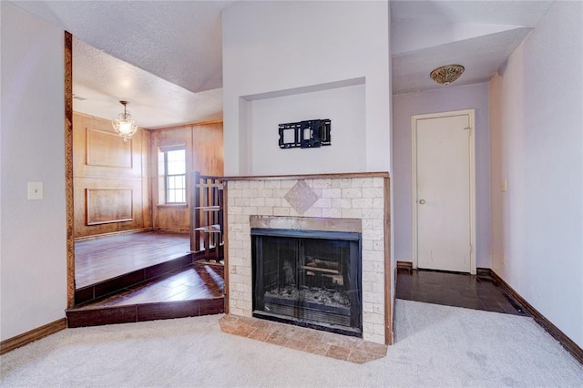 unfurnished living room with a fireplace, carpet floors, and a textured ceiling