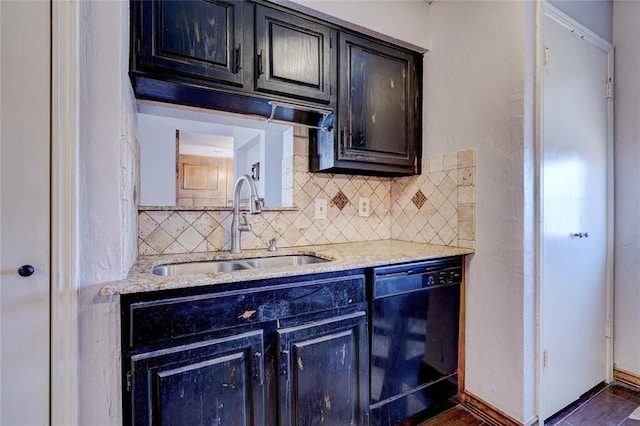 kitchen with light stone counters, black dishwasher, sink, and decorative backsplash